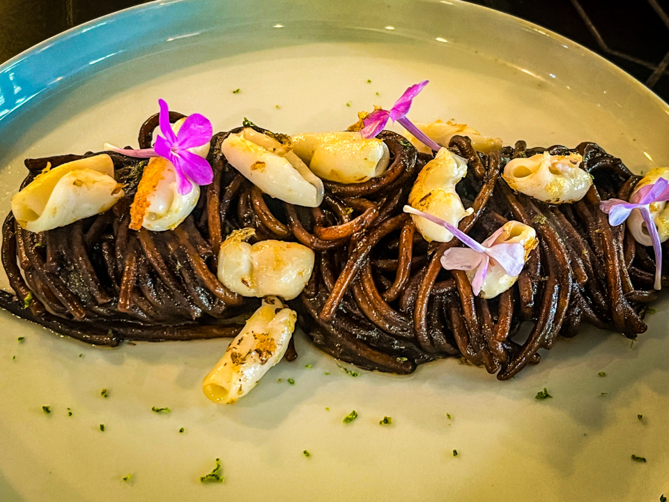 Spaghetti with black garlic sauce, squid, and chili flakes – a bold Italian pasta dish with rich flavors and a hint of spice.