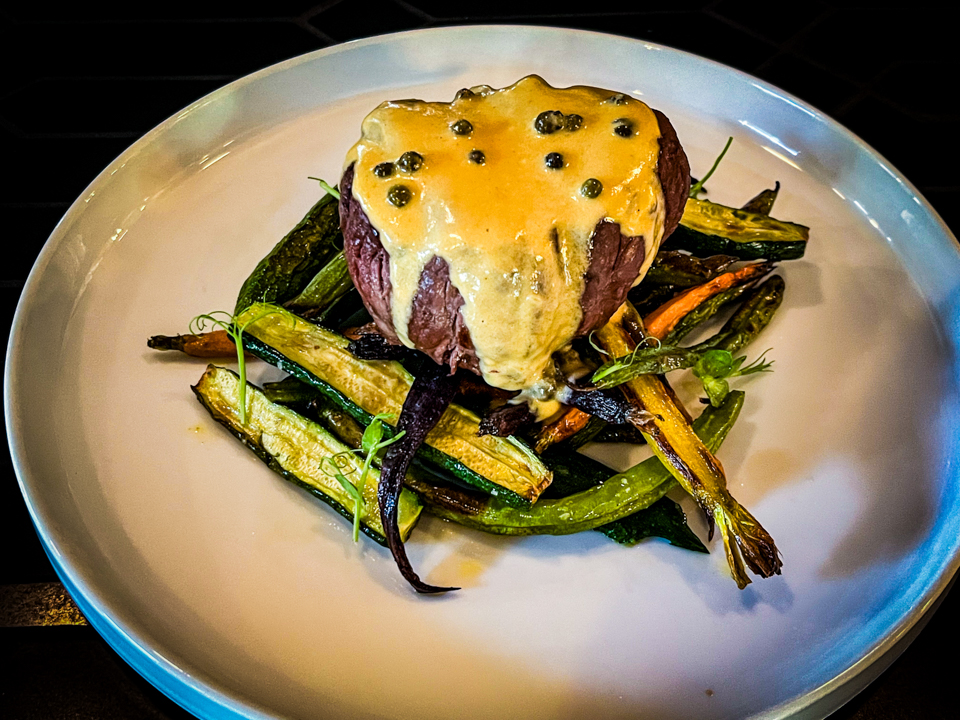 Filetto al Pepe Verde – Tender beef fillet topped with a creamy green peppercorn sauce, served with a side of roasted vegetables.